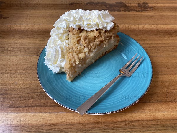 Piece of apple pie with whipped cream on plate, cake fork, wooden table, Frankfurt am Main, Hesse, Germany, Europe