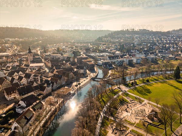 Aerial view of a river town with bridges and a church, surrounded by residential areas and green spaces, sunrise, Nagold, Black Forest, Germany, Europe