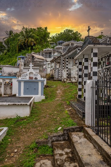 Famous cemetery, many mausoleums or large tombs decorated with tiles, often in black and white. Densely built buildings under a sunset Cimetiere de Morne-a-l'eau, Grand Terre, Guadeloupe, Caribbean, North America