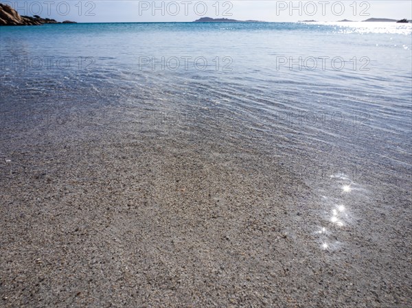 Waves reach the sandy beach, glittering sea, Capriccioli beach, Costa Smeralda, Sardinia, Italy, Europe