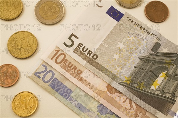 Close-up of five, ten, twenty Euro bank notes and assorted 2, 5, 10, 50 cent coins on white background, Studio Composition, Quebec, Canada, North America