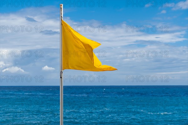 Yellow flag on the beach in summer summer, lifeguards sign