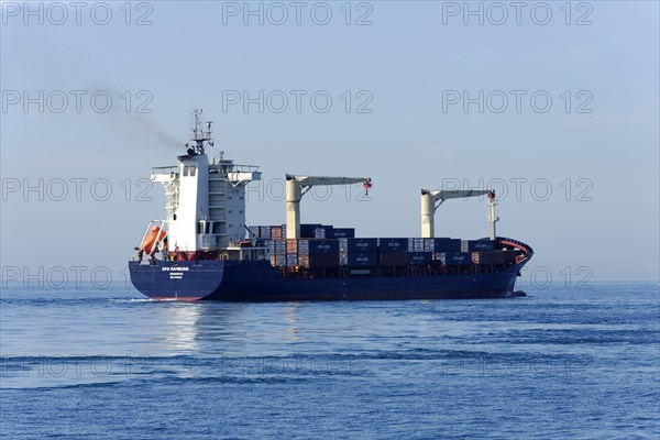 OPS HAMBURG, A large container ship sails on the sea against the blue sky, Marseille, Departement Bouches-du-Rhone, Provence-Alpes-Cote d'Azur region, France, Europe