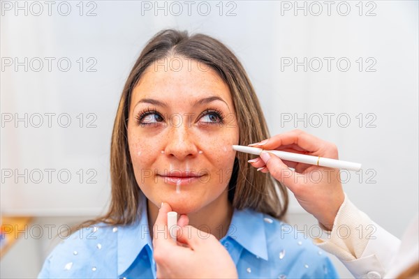 Plastic surgeon drawing lines in the face of a women marking where to injecting hyaluronic acid