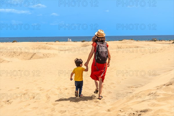 Mother and child on vacation in the dunes of Maspalomas, Gran Canaria, Canary Islands