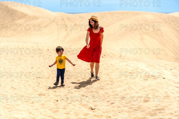 Mother and son tourists on vacation very happy in the dunes of Maspalomas, Gran Canaria, Canary Islands
