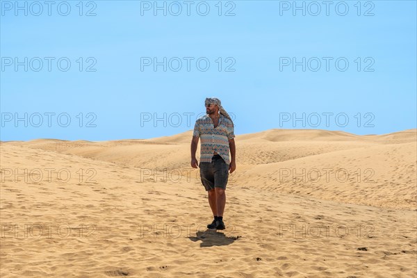 Tourist man with turban in summer in the dunes of Maspalomas, Gran Canaria, Canary Islands