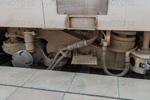 Train suspension and hydraulic systems close-up next to a platform, in South Korea