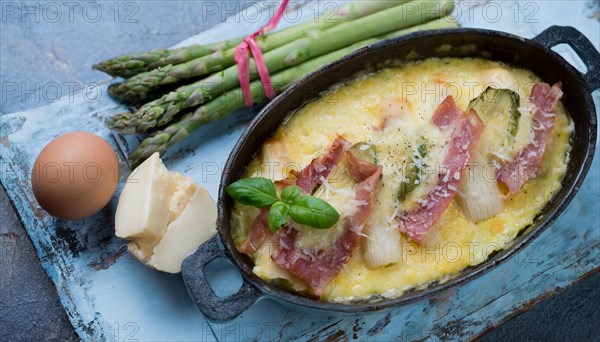 Hearty asparagus casserole with ham and egg served on a rustic wooden board, asparagus casserole with green asparagus, cheese and ham, KI generated, AI generated