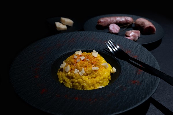 Elegant Plate with Saffron Risotto alla Milanese and Luganighe with Parmesan Cheese in Lugano, Ticino, Switzerland, Europe
