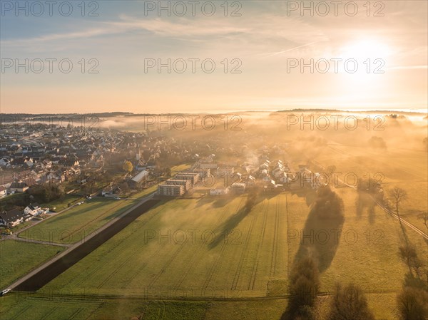 Sunrise behind a small town with fog over the fields in the foreground, Gechingen, Black Forest, Germany, Europe