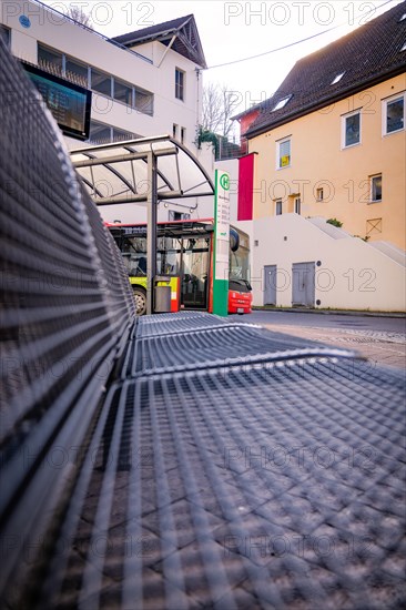 A bus stop with timetable and bench in front of half-timbered houses, Calw, Black Forest, Germany, Europe