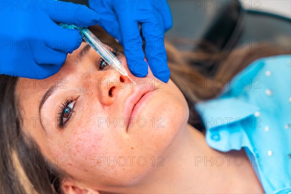 Close-up of a woman receiving a beauty treatment with collagen to full up her lips