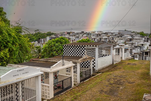 Famous cemetery, many mausoleums or large tombs decorated with tiles, often in black and white. Densely built buildings under a dramatic cloud cover Cimetiere de Morne-a-l'eau, Grand Terre, Guadeloupe, Caribbean, North America