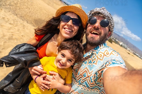 A happy family on summer holidays in the dunes of Maspalomas, Gran Canaria, Canary Islands