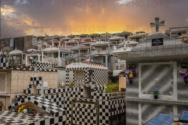 Famous cemetery, many mausoleums or large tombs decorated with tiles, often in black and white. Densely built buildings under a sunset Cimetiere de Morne-a-l'eau, Grand Terre, Guadeloupe, Caribbean, North America