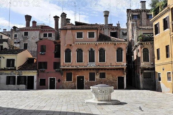 An empty square surrounded by colourful historic buildings in Italy, with a fountain in the middle, Venice, Veneto, Italy, Europe