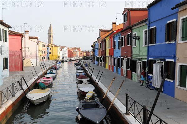 Colourful houses, Burano, Burano Island, Colourful houses line up along a quiet canal with parked boats, Burano, Venice, Veneto, Italy, Europe