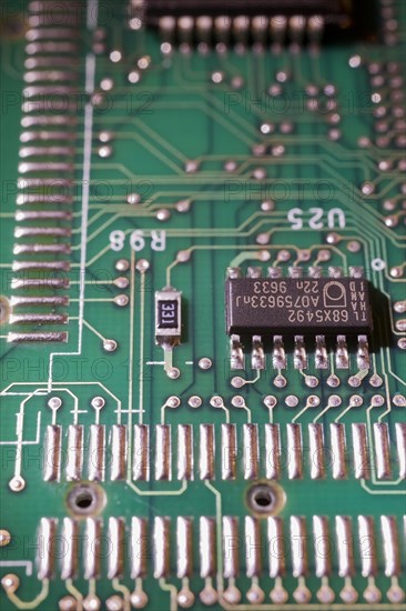 Close-up of green electronic computer circuit board with microchip, silver solder points and lines, Studio Composition, Quebec, Canada, North America