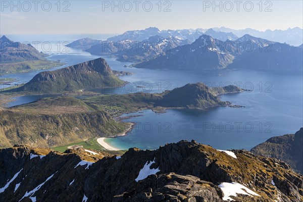 Landscape with sea and mountains. Descent from Himmeltindan mountain. View of the light-coloured sandy beach of Vik (Vik Beach) and Vik Bay (Vikbukta) . Mount Offersoykammen on the left, Skottinden on the edge, the mountains of Flakstadoya in the background. Vestvagoya, Lofoten, Norway, Europe