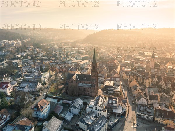 A sunset casts warm light on the cityscape with a prominent church, Sunrise, Nagold, Black Forest, Germany, Europe