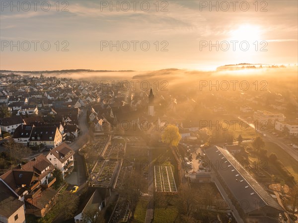 Sunrise over a fog-covered small town with a striking church tower, Gechingen, Black Forest, Germany, Europe