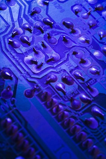 Close-up of blue purple lighted electronic computer circuit board with silver solder points, Studio Composition, Quebec, Canada, North America