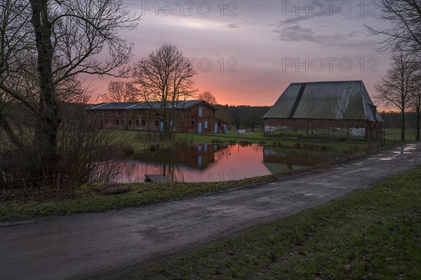 Evening atmosphere with stables and fire pond on an old farm from 1921, Othenstiorf, Mecklenburg-Vorpommern, Germany, Europe