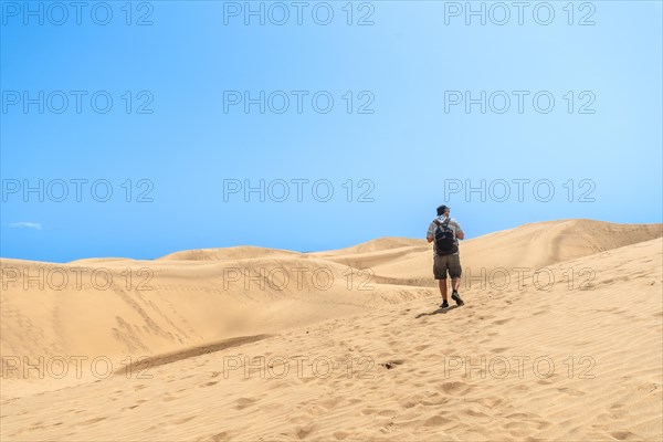 A man tourist enjoying in the dunes of Maspalomas, Gran Canaria, Canary Islands