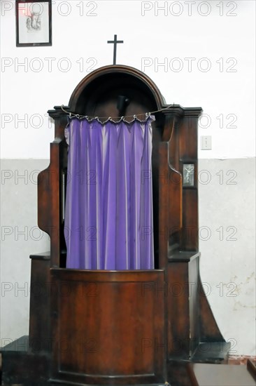 Old wooden confessional with purple curtain in a church, Venice, Veneto, Italy, Europe
