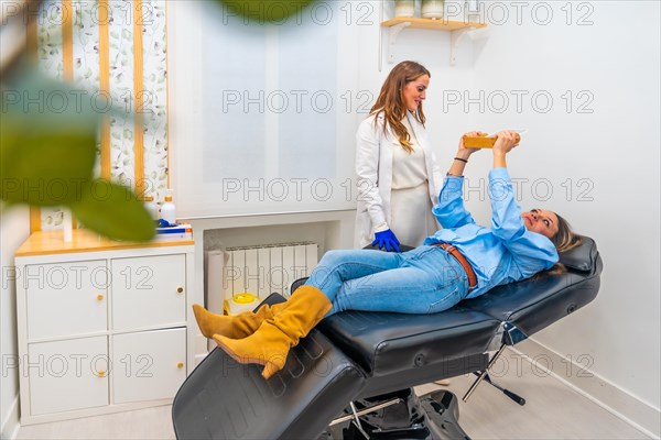 Woman looking at the mirror after beautician treatment next to a doctor in the clinic