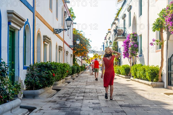 A woman walking in the port of the coastal town Mogan in the south of Gran Canaria. Spain