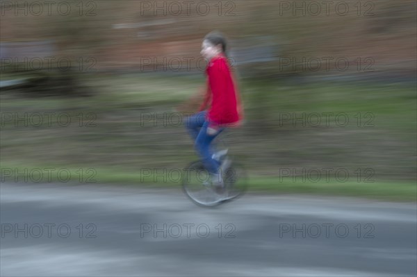 Girl, 10 years old, riding a unicycle, motion blur, Mecklenburg-Vorpommern, Germany, Europe