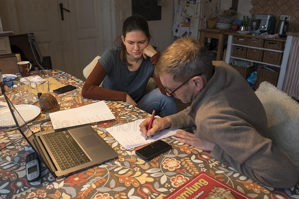 Father with his daughter planning the day for tomorrow at the dining table, Mecklenburg-Vorpommern, Germany, Europe