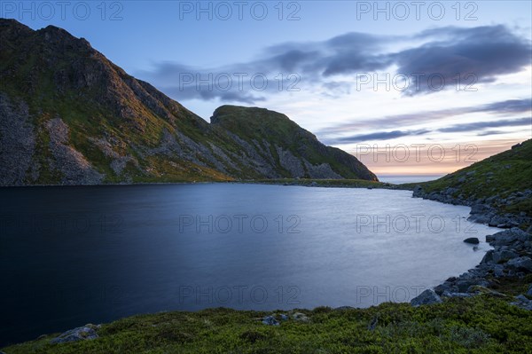 Lake Utdalsvatnet and the Hogskolmem mountain range. At night during the midnight sun in good weather. Unstad, Vestvagoya, Lofoten, Norway, Europe