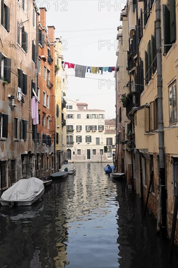 View of a Venetian canal with boats and washing lines between the houses, Venice, Veneto, Italy, Europe