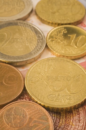 Close-up of gold and copper colored assorted five, ten, fifty Euro cent coins on top of Euro bank note, Studio Composition, Quebec, Canada, North America