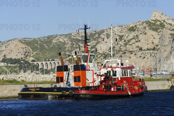 Red tugboat waiting in the harbour area next to a jetty, Marseille, Departement Bouches-du-Rhone, Region Provence-Alpes-Cote d'Azur, France, Europe