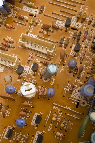 Close-up of orange electronic computer circuit board with capacitors and transistors, Studio Composition, Quebec, Canada, North America