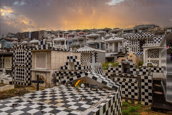 Famous cemetery, many mausoleums or large tombs decorated with tiles, often in black and white. Densely built buildings under a sunset Cimetiere de Morne-a-l'eau, Grand Terre, Guadeloupe, Caribbean, North America