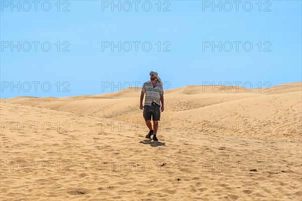 Tourist man with turban in summer walking in the dunes of Maspalomas, Gran Canaria, Canary Islands