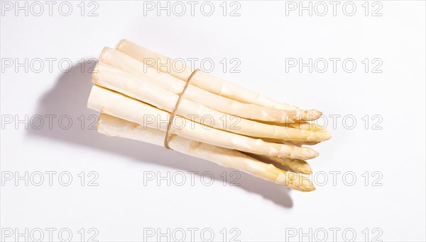 A bunch of white asparagus lies on a white background with shadows, AI generated, AI generated