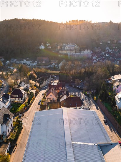 The drone image shows a street in a residential area during sunset, Calw, Black Forest, Germany, Europe