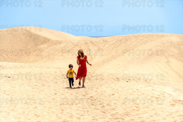 Mother and son tourists on vacation in the dunes of Maspalomas, Gran Canaria, Canary Islands