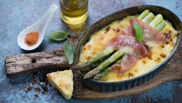 Baked asparagus with ham and cheese served in a casserole dish, asparagus casserole with green asparagus, cheese and ham, KI generated, AI generated