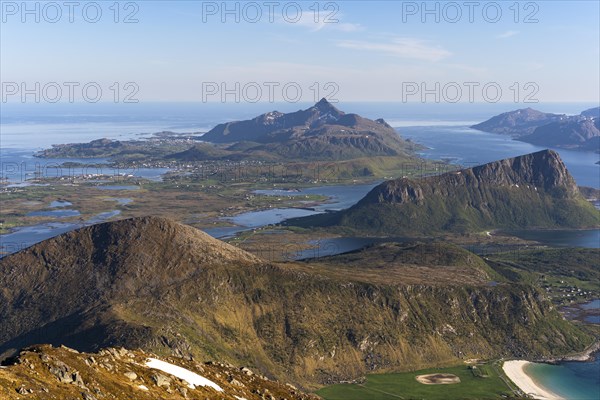 Landscape with sea and mountains. Descent from Himmeltindan mountain. View of the light-coloured sandy beach of Vik (Vik Beach), Mount Offersoykammen on the right, Skottinden in the background. Early summer. Vestvagoya, Lofoten, Norway, Europe