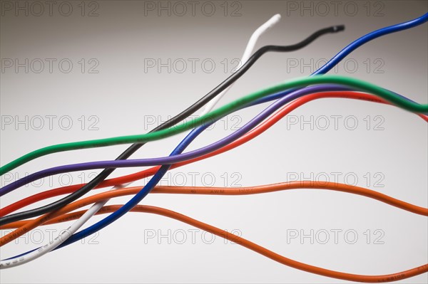 Close-up of orange, red, green, blue, purple, white and black shielded electrical copper wires on white background, Studio Composition, Quebec, Canada, North America