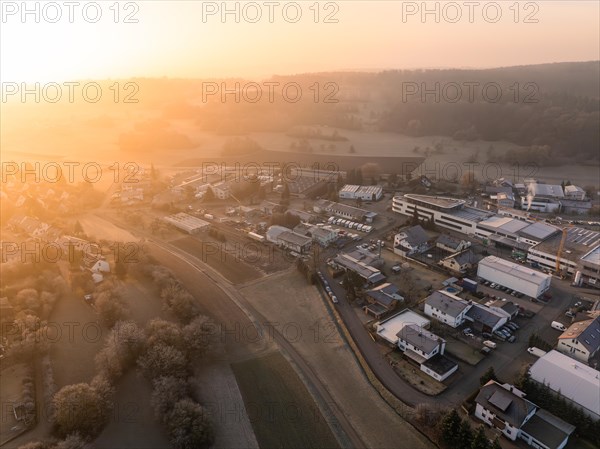 Morning light sweeps over an industrial estate and casts long shadows between the buildings, Gechingen, Black Forest, Germany, Europe