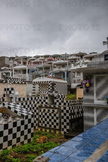 Famous cemetery, many mausoleums or large tombs decorated with tiles, often in black and white. Densely built buildings under a dramatic cloud cover Cimetiere de Morne-a-l'eau, Grand Terre, Guadeloupe, Caribbean, North America