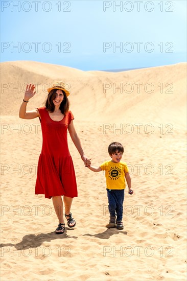 Mother and son tourists enjoying in the dunes of Maspalomas, Gran Canaria, Canary Islands